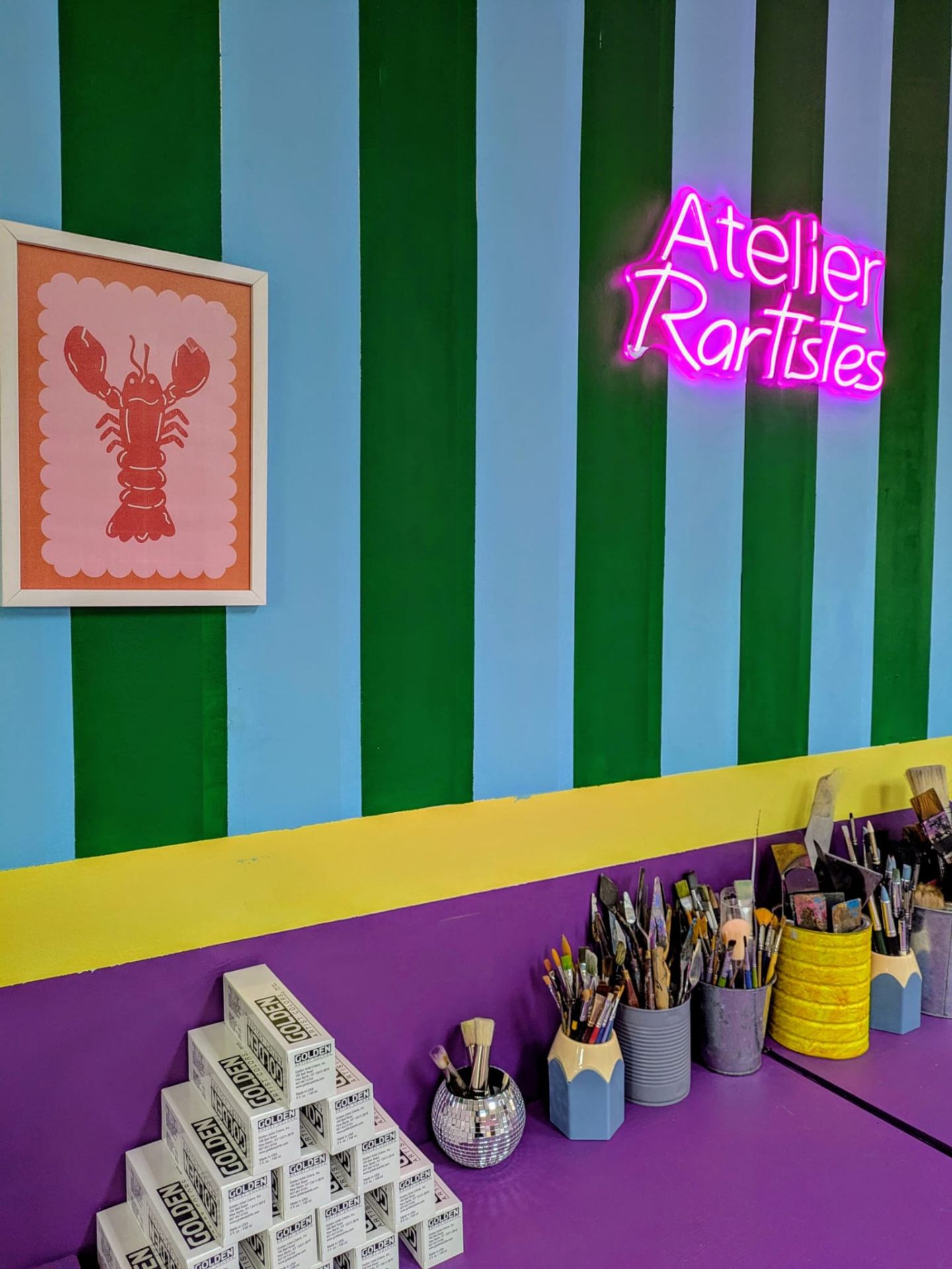 Espace créatif Rartistes - Cours d'art à Capinghem Atelier Rartistes à Capinghem - Enseigne néon rose et étagères d'outils artistiques
